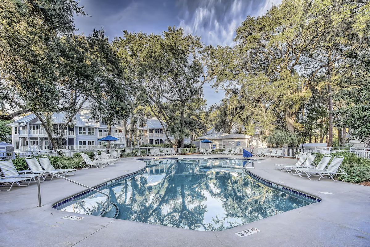 The shaded villa pool under live oaks